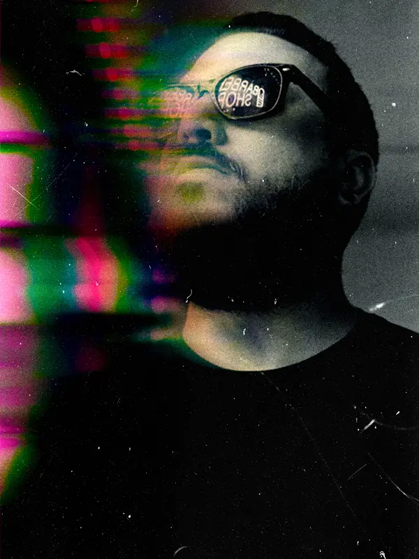 Portrait of a person in sunglasses looking upward with colorful light streaks across the frame.
